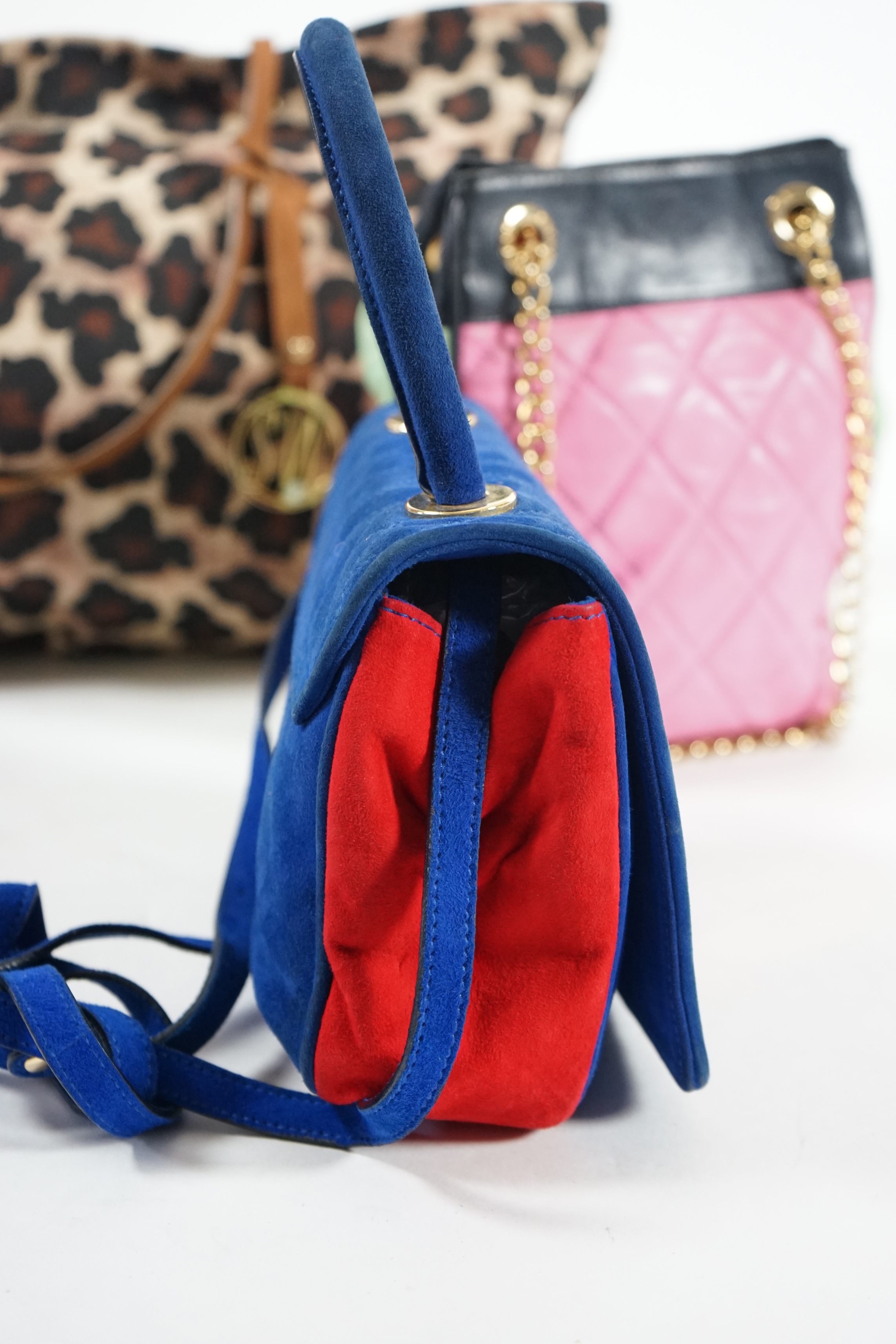 A selection of lady's handbags, including an animal print Stuart Weitzman shoulder bag with dust bag, an Escada suede royal blue and red shoulder bag, and another Escada handbag in navy blue with pink and light green qui